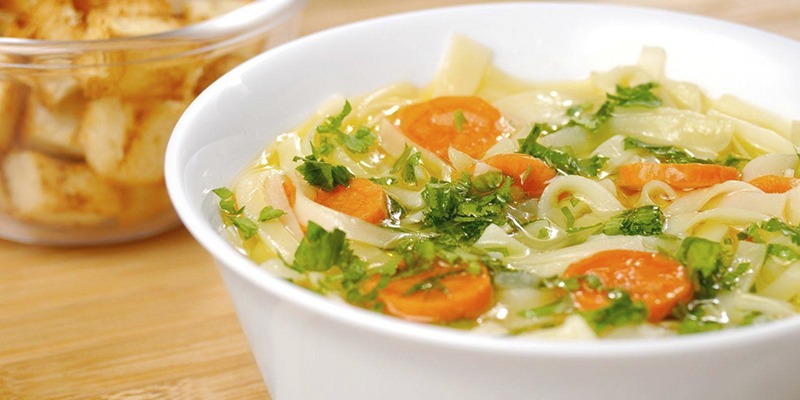 Hearty gluten-free vegetable soup in a rustic bowl with fresh herbs